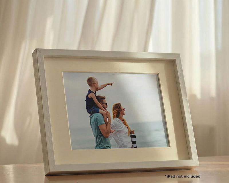 iFramix Pro white wooden smart frame kit repurposing an idle iPad into a digital photo frame, shown displaying a family beach vacation photo.